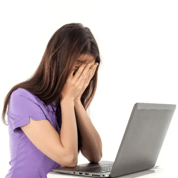 Intentional Approach to Mentorship. Woman sitting with her elbows on her laptop, cradling her face in her hands 