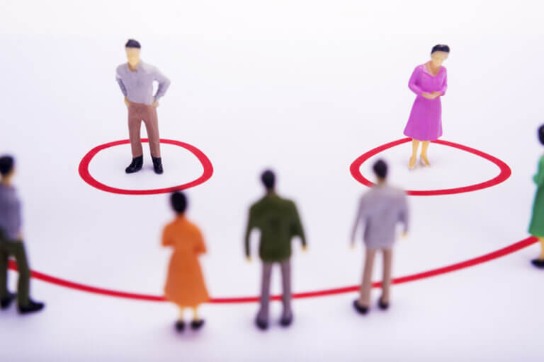 Photo of two toy human figures standing in separate circles, representing transcribers who prefer on-site or remote transcribing