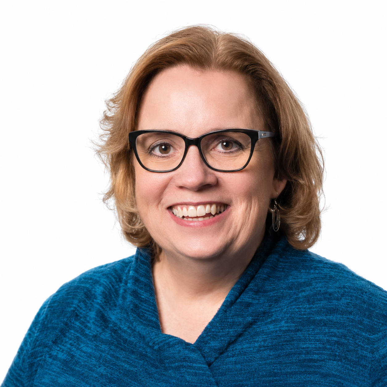 Professional headshot of a smiling woman wearing glasses and a blue sweater against a white background.